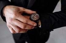 businessman looks at the watch on his wrist, looks at the time. High quality photo.