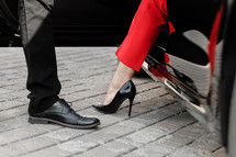 Close up image of a business woman getting out of her car with high heels shoes
