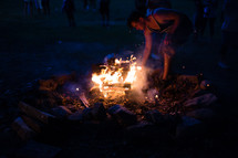 man tending to a campfire 