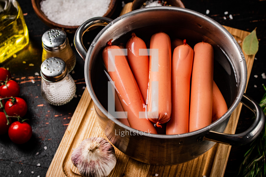 Delicious sausages boiled on the table. On a black background. High quality photo