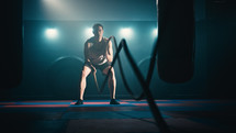 Fitness athlete training using battle ropes intense workout