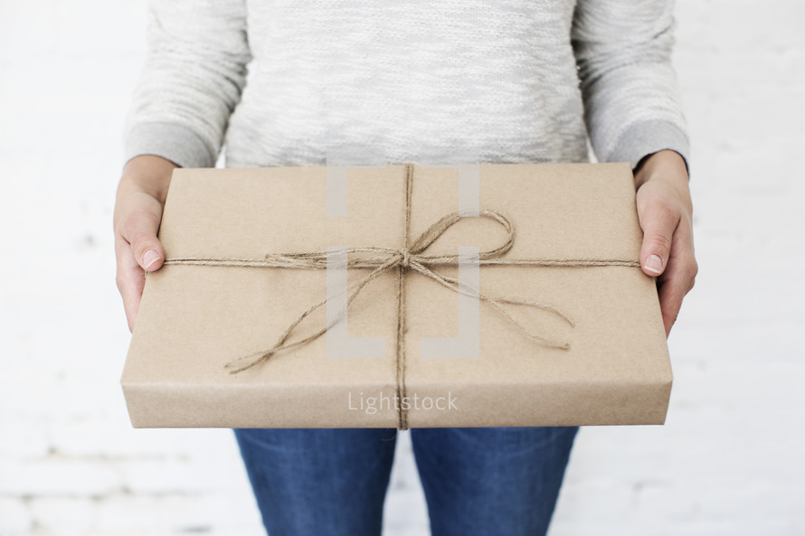 Woman holding a wrapped gift.