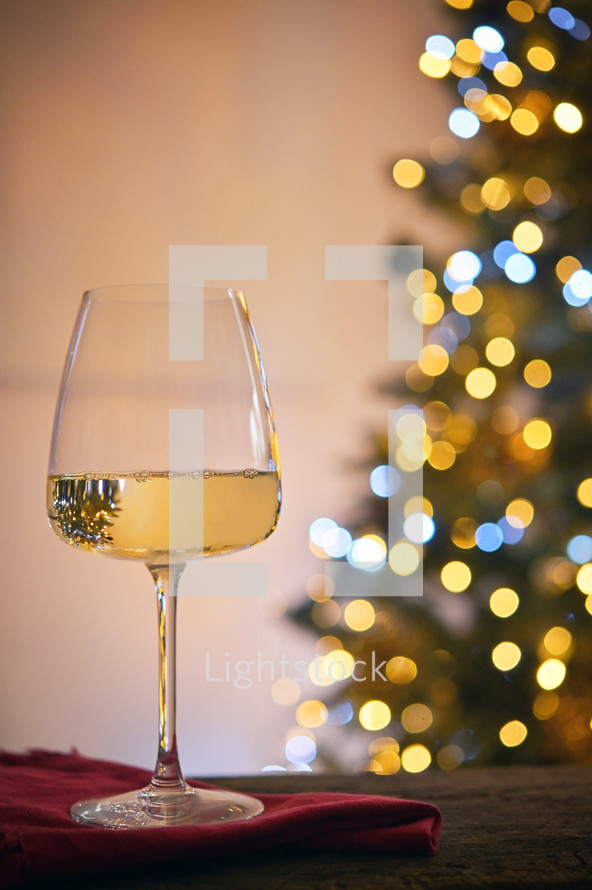 Wine glass next to a Christmas tree