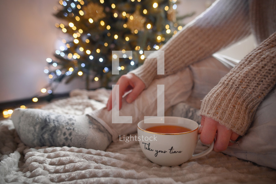 Woman with mug and Christmas tree