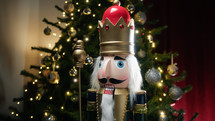 Nutcracker in front of Christmas tree