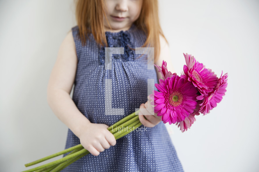 little girl holding flowers.