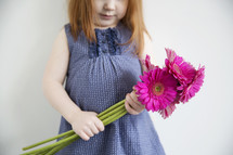 little girl holding flowers.
