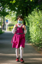 Little school girl going back to school after pandemic outbreak wearing an face mask