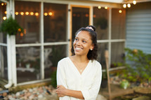 smiling woman standing on a back porch 