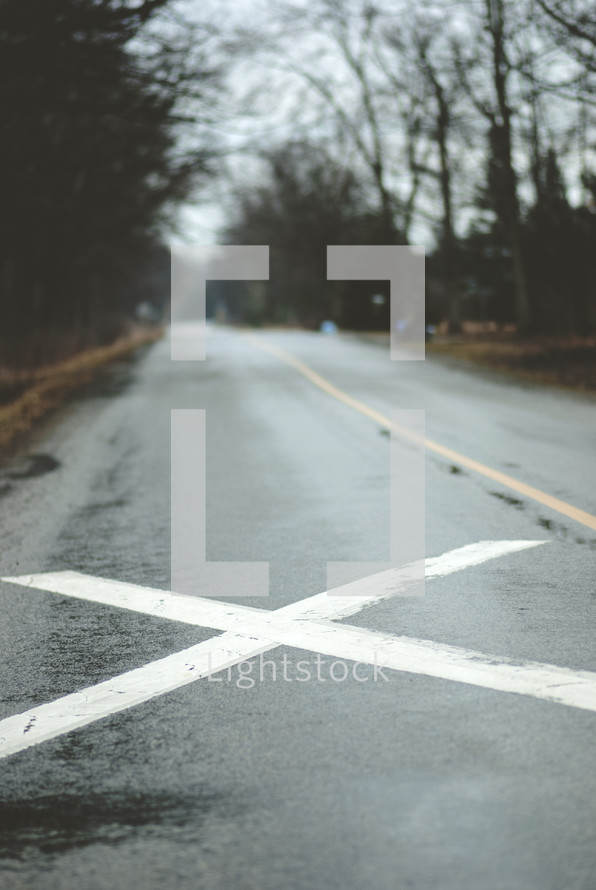 an X in the middle of a wet road 