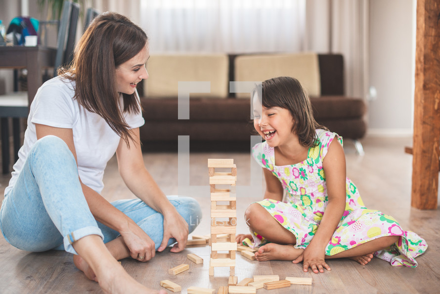 a mother and daughter playing Jenga