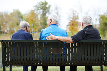 elderly men talking outdoors 