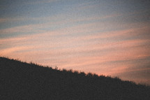 a hill and sky at sunset 