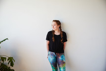 a woman in yoga pants leaning against a white wall 