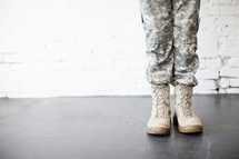 Legs and feet of a female soldier in uniform.