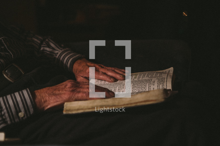 elderly man reading a Bible in his lap