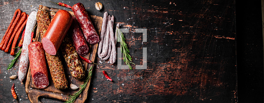 Assortment of various aromatic salami sausages. Against a dark background. High quality photo