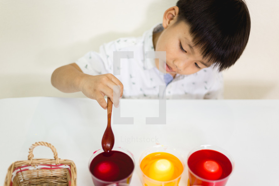 a boy dying Easter eggs