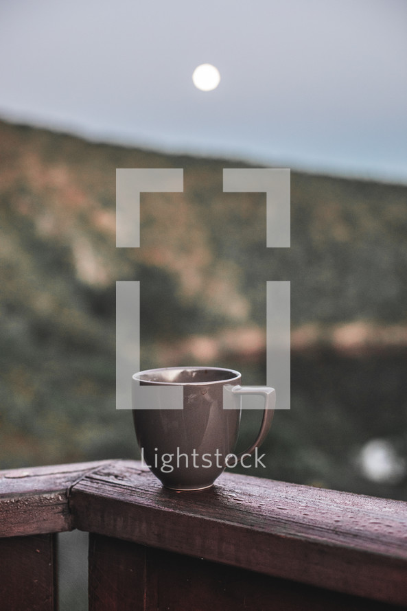 coffee mug on a railing 
