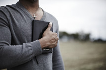 A man holding a bible over his heart