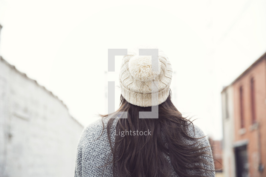 back of a woman's head and wool cap