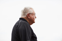 elderly man standing against a white background 