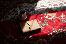 A Bible in a sun spot on a carpet 