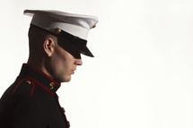 Marine soldier in uniform bowing his head in prayer.

