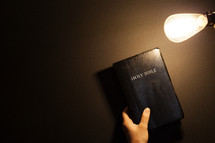 Shining an Edison light on a Bible. 