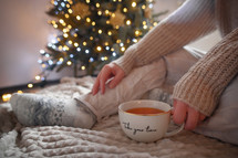 Woman with mug and Christmas tree