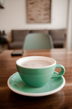 mint green coffee cup on a wood table 