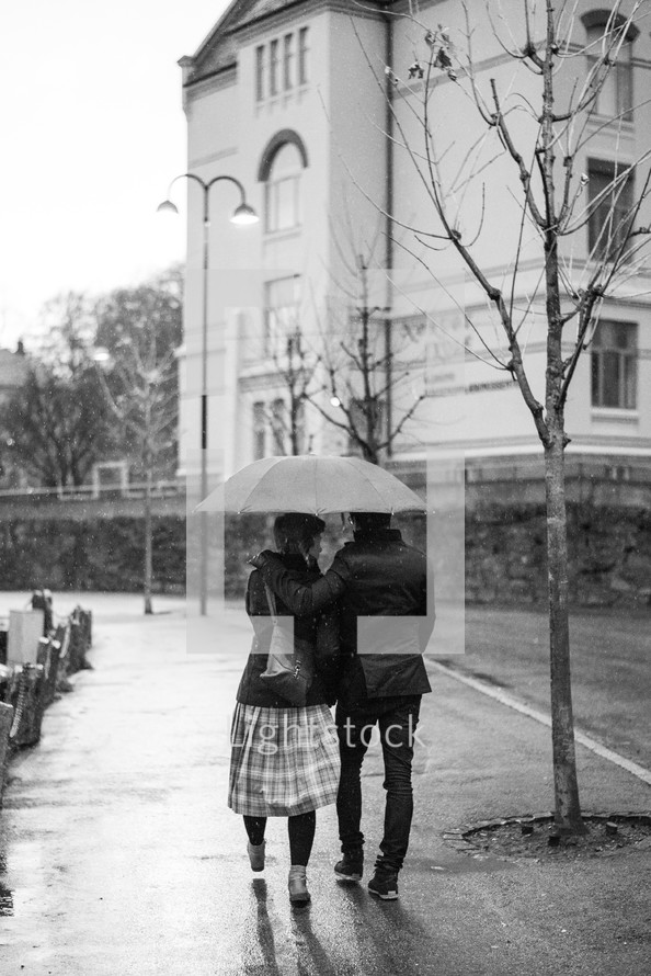 couple walking together under an umbrella 