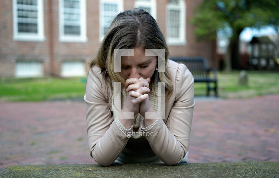 a woman praying on the ground 