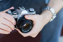 A man's hands holding a camera.