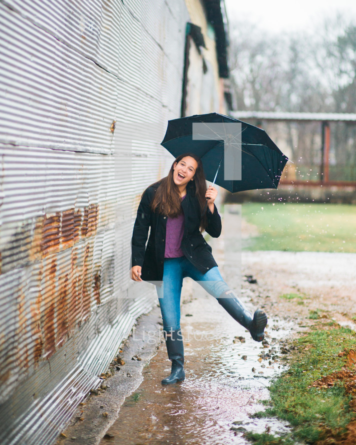 teen girl playing in the rain 
