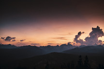 clouds above mountain peaks at sunrise 