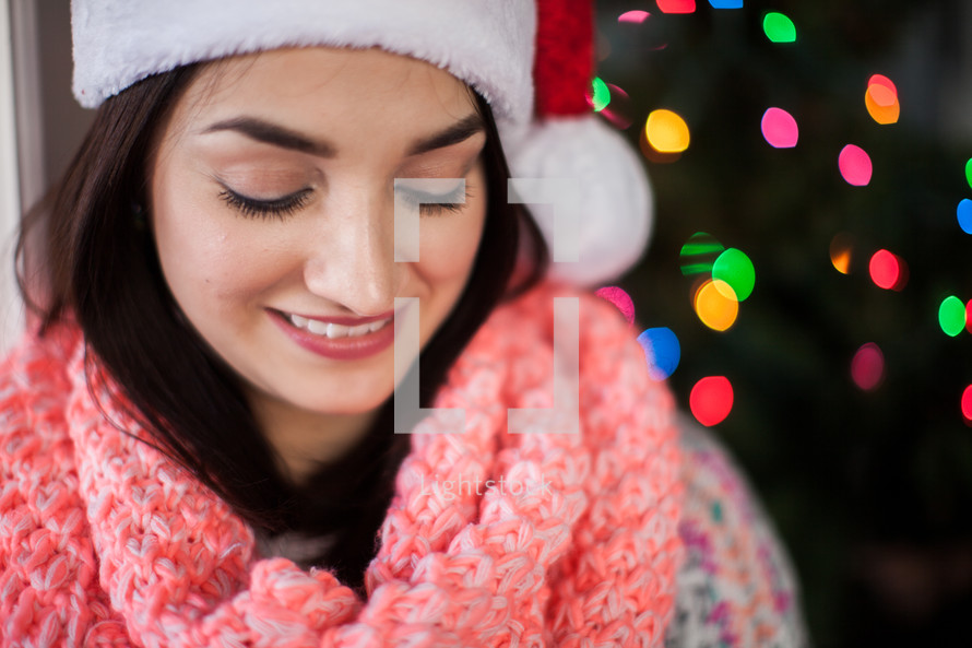 A smiling young woman wearing a santa hat