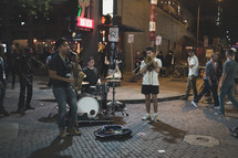 street musicians performing on a street corner at night 