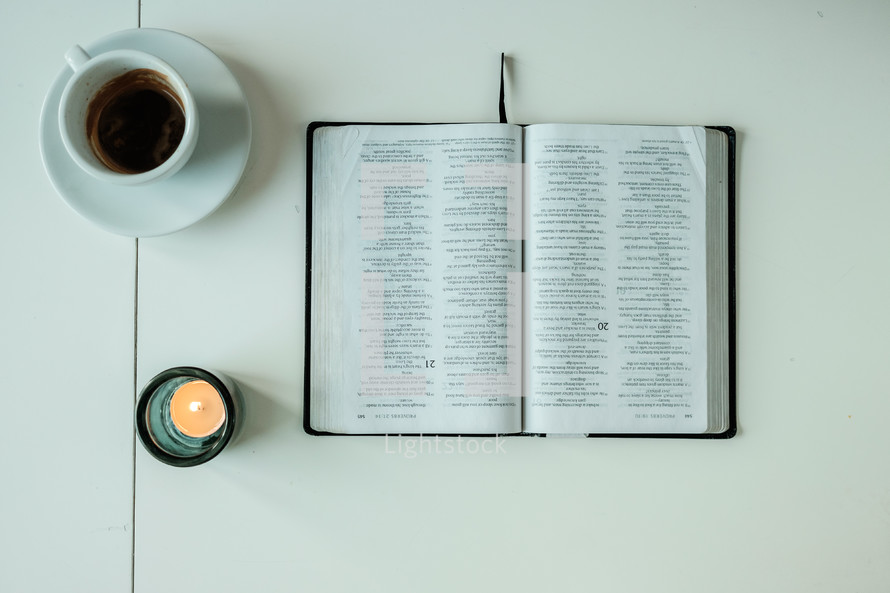 coffee cup, open Bible, votive candle, pages 
