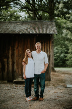 couple standing in front of a barn 