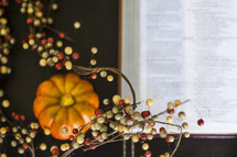 fall decorations,  berries and pumpkin, and an open Bible 