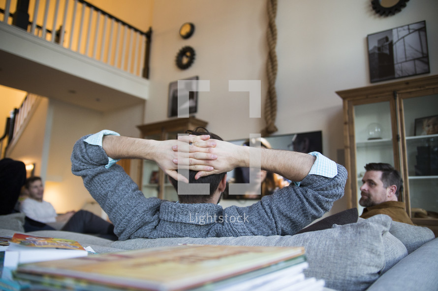 Men sitting on a couch  watching  tv   Photo  Lightstock