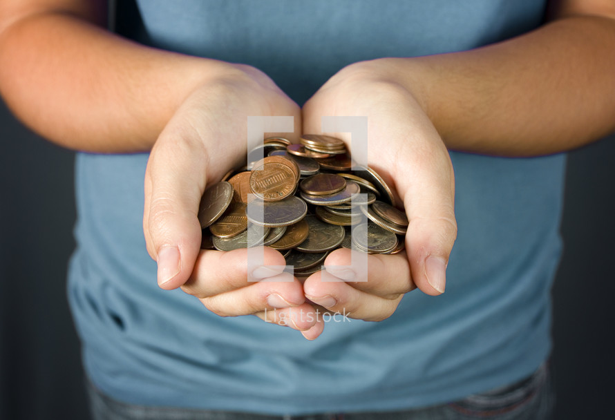 A young girl holding out a pile of coins