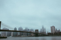fog over a bridge and city skyscrapers 