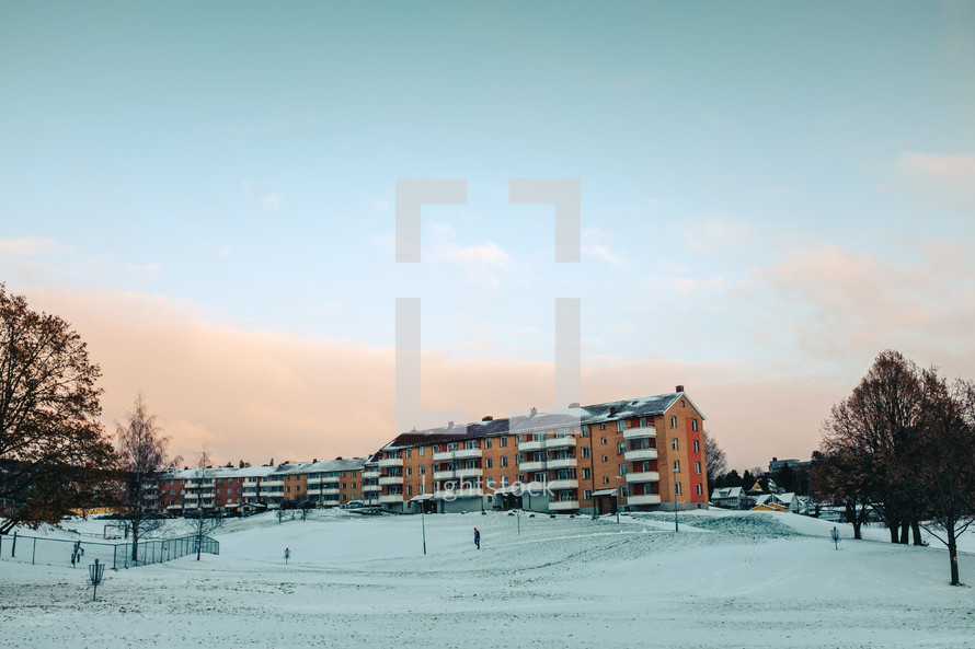 apartments and a snow covered hill 