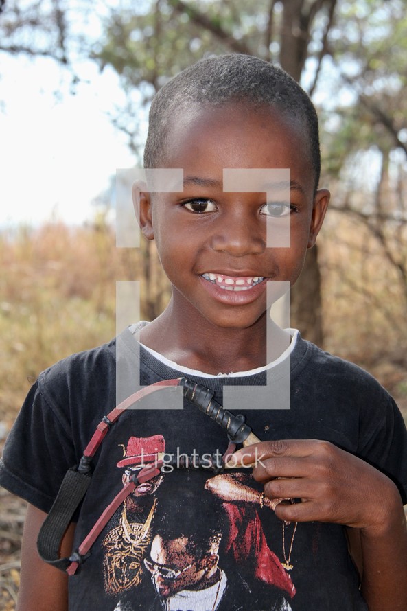 smiling boy child holding a sling-shot 