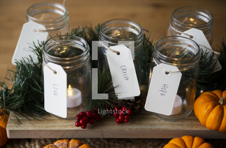Tealight candles in jars for advent with pumpkins and Christmas decor