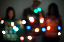 friends holding glowing Christmas lights 