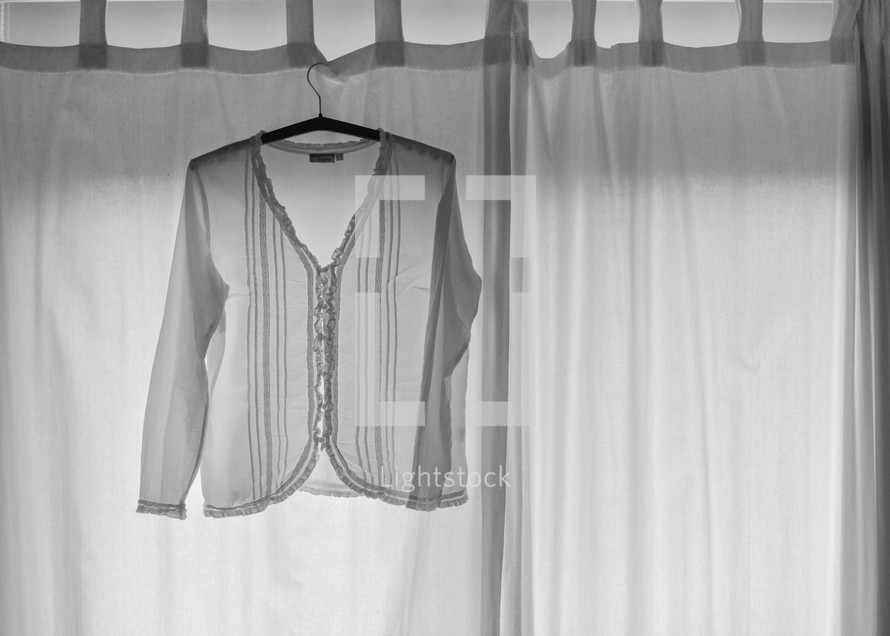 white shirt hanging in a window 