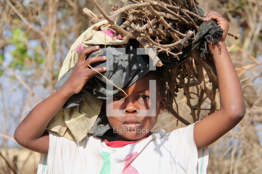 child carrying sticks on his head